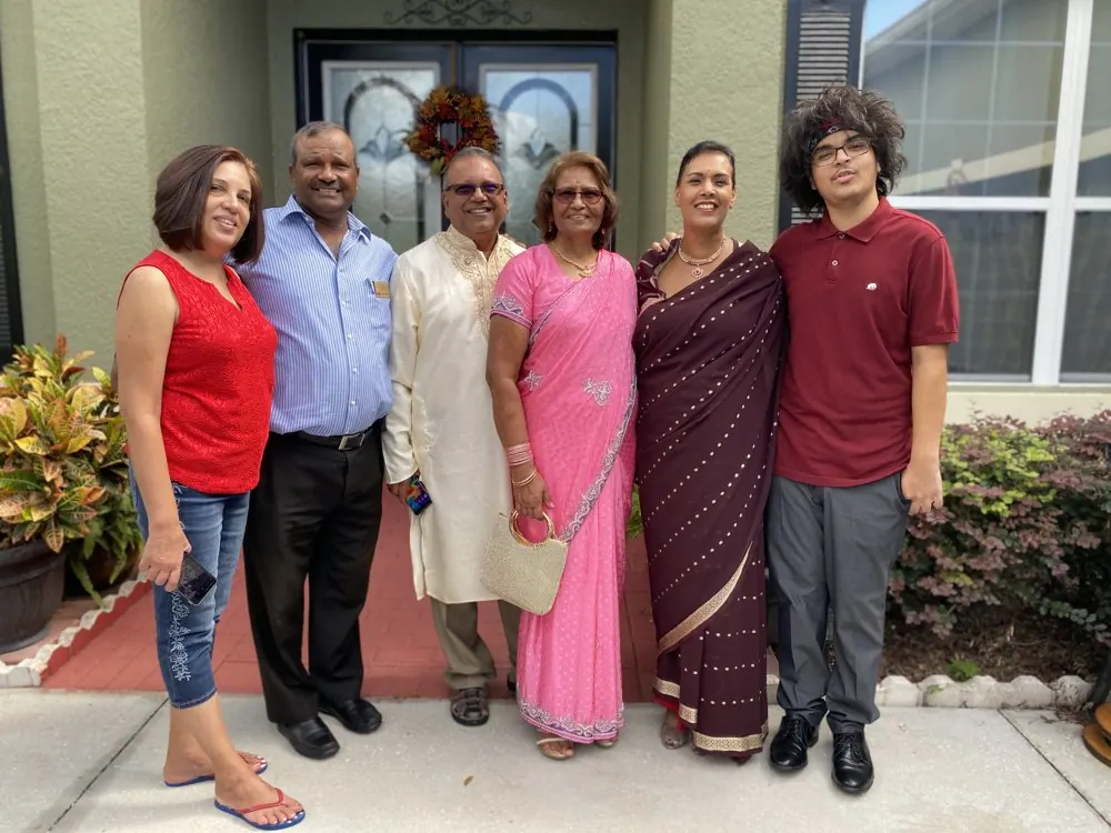 Kris Persaud with family at a front door