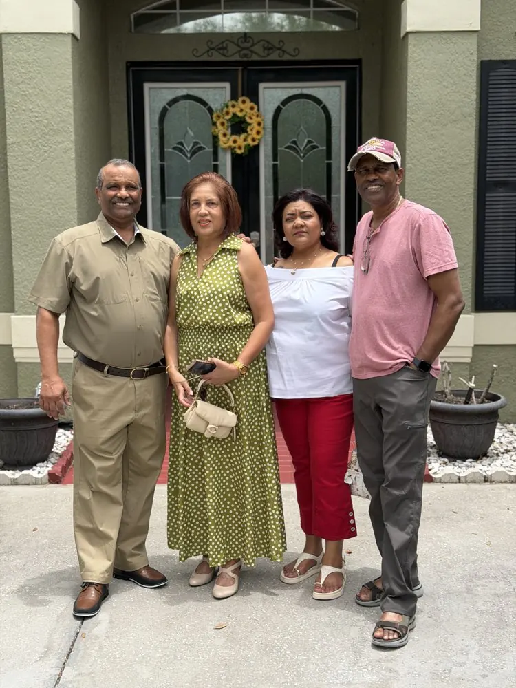 Kris Persaud with family and friends outside a home